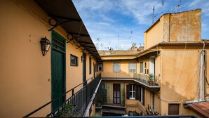Un edificio de varios pisos con balcones, una escalera y cielo despejado.