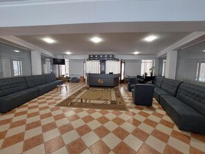 A spacious lobby with a checkered floor, sofas, a reception desk, and a flat-screen TV. - University Hotel Tsakhkadzor (Tsaghkadzor)