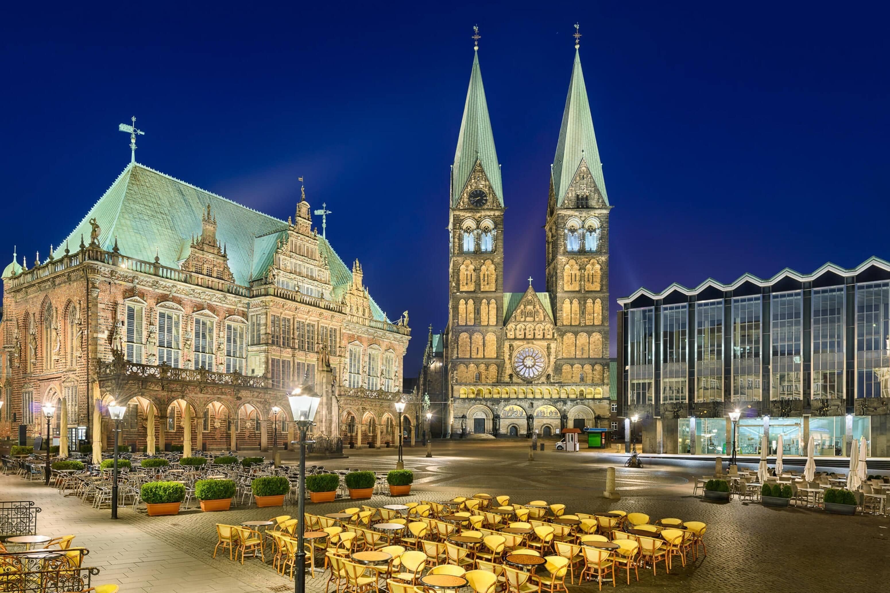 A historic building with a clock tower and a modern glass structure.