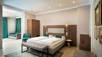 A modern bedroom with a double bed, a bench, a bedside table, and a large window.