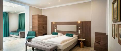 A modern bedroom with a double bed, a bench, a bedside table, and a large window.