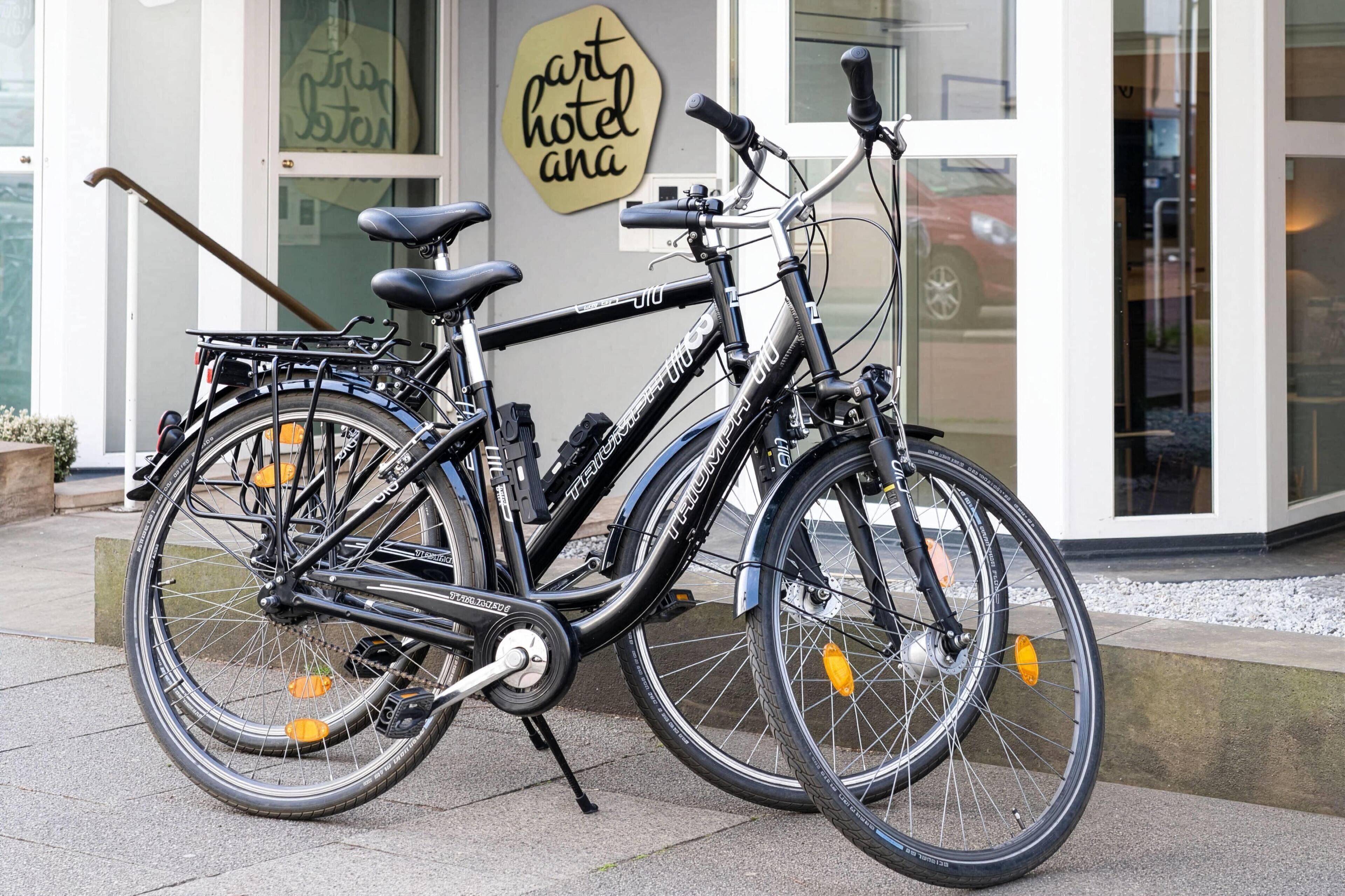 Una bicicleta estacionada frente a un edificio con un letrero que dice 'part hotel ana'.
