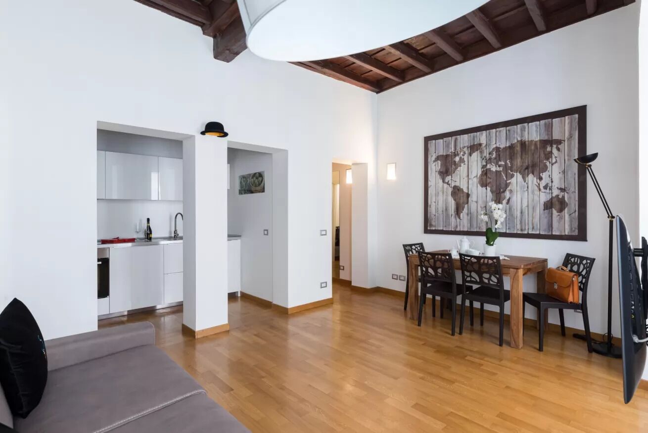 Un espacio moderno para vivir con cocina, comedor y una gran obra de arte con un mapa del mundo.