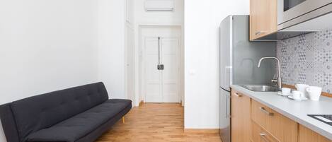 A modern kitchen with wooden cabinets, a built-in oven, and a stainless steel refrigerator.