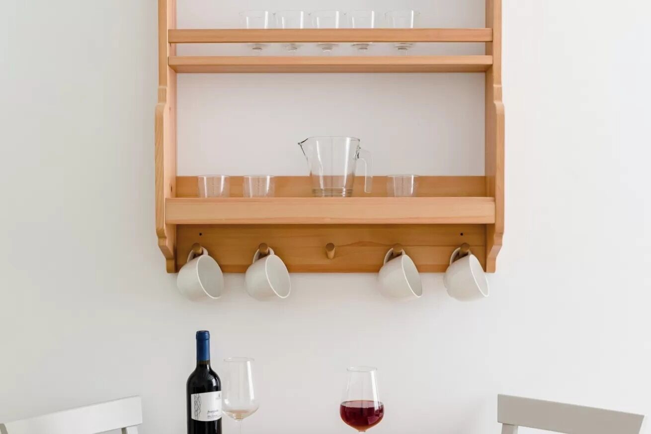 Een houten plank met verschillende glazen en een wijnfles.