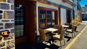 Ein Restaurant mit Außenbereich, Steinwänden und Holzbalken.