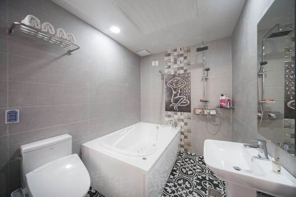 A modern bathroom with a bathtub, toilet, and sink. - Samho Hotel (Yeongam)