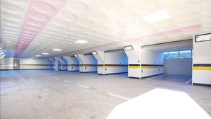 Un espacio interior amplio con un diseño de techo moderno, varias entradas y un suelo limpio y despejado.