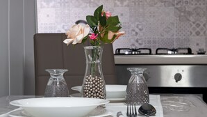 A dining table set with plates, cutlery, and a vase with flowers. - Voglia di Napoli (Naples)