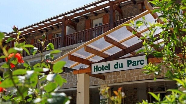 A hotel entrance with a sign reading "Hotel du Parc" and an entrance sign indicating a restaurant. - Hôtel du parc (Val-d'Aigoual)