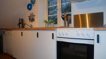 A kitchen with white cabinets, a stainless steel range hood, and a built-in oven.