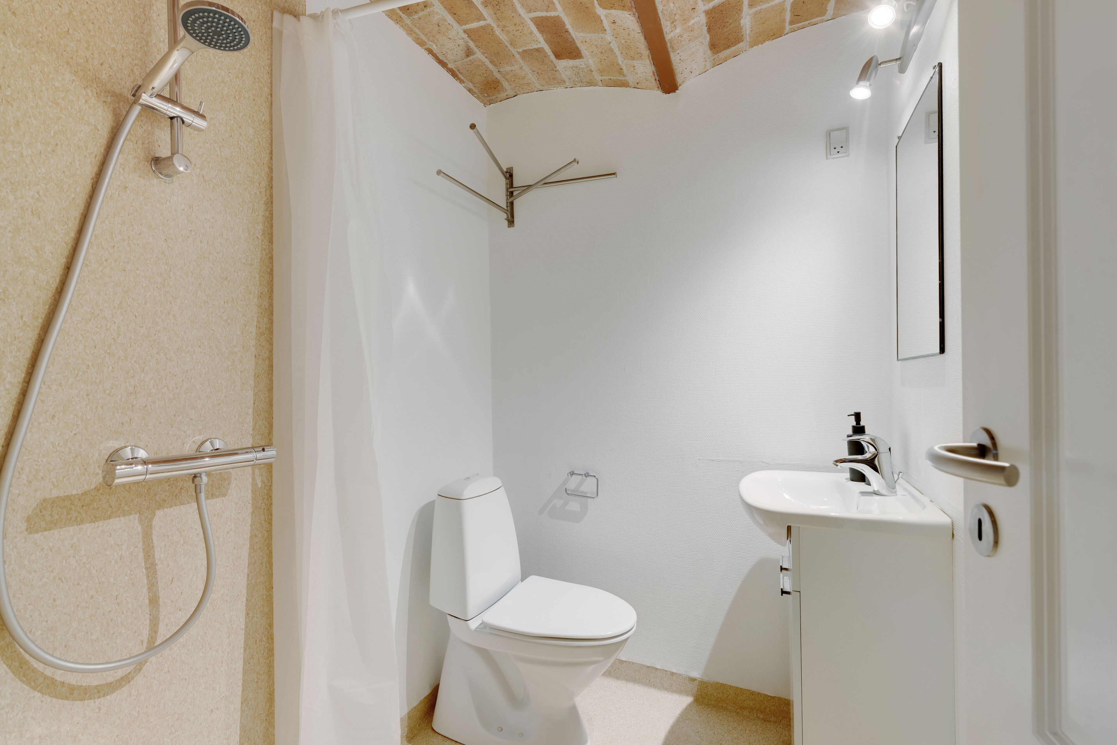 Un baño con ducha, inodoro y lavabo.