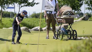 Golfers can enjoy a round on our scenic course, surrounded by lush greenery and trees.