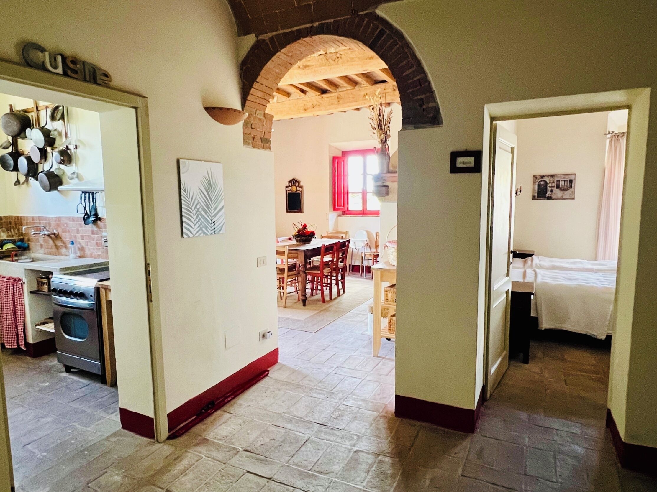 Une cuisine équipée d’une cuisinière, de casseroles et d’une pancarte indiquant « Cuisine », qui donne sur un coin repas avec une table et des chaises.