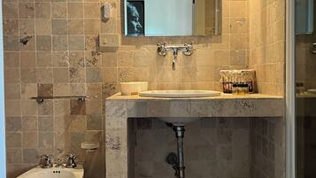 Un bagno con lavandino, specchio e doccia.