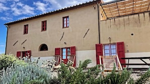 A two-story building with red shutters and a balcony. - Fattoria Podere i Luoghi (Casale Marittimo)