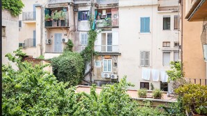 A multi-story building with balconies, some with plants. There are air conditioning units on the exterior walls. - Via Laurina 40 Apartment (Rome)