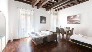 A modern room with a bed, a desk, and a dining area. - A World Apart - Trevi Apartments (Rome)