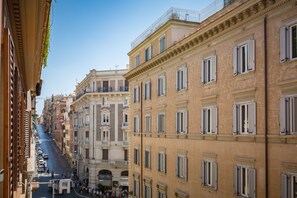 A street view of a historic building with multiple floors, large windows, and balconies. - A World Apart - Trevi Apartments (Rome)