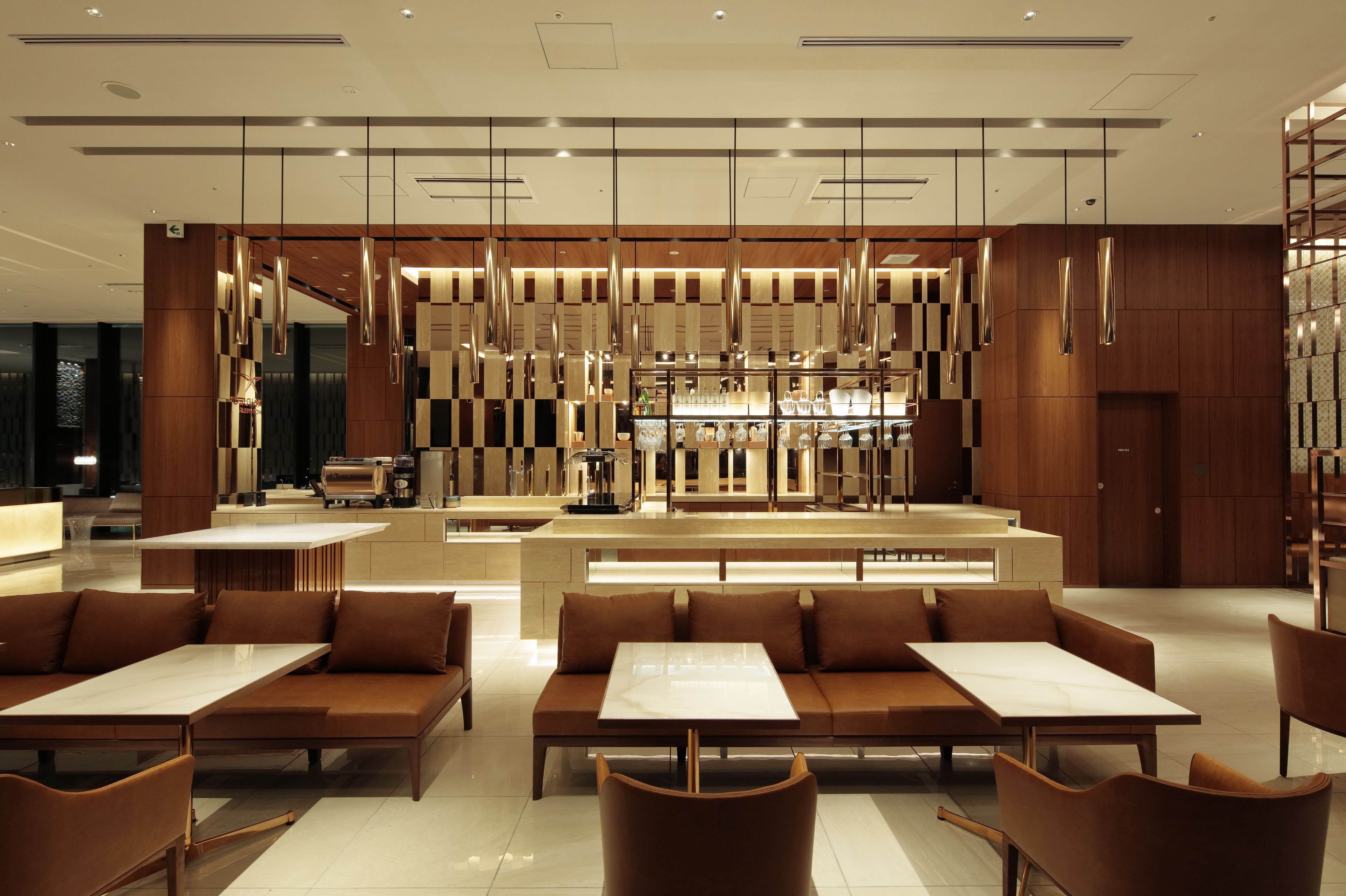 A modern hotel lobby with a central bar area, seating arrangements, and a contemporary design.
