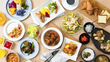 A variety of dishes including salad, meat, and bread, arranged on a wooden table.