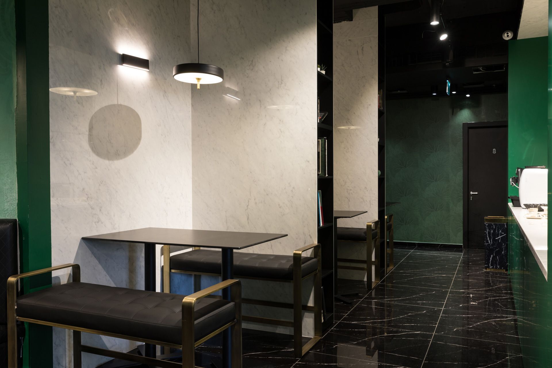 Ein modernes Interieur mit Marmorwänden, schwarzem Fliesenboden und minimalistischer Einrichtung.