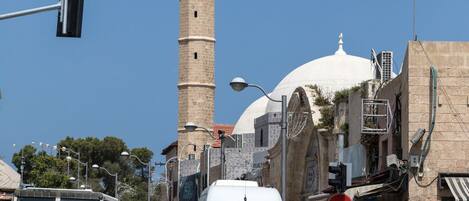 A street with a tall minaret and a mosque with a dome.