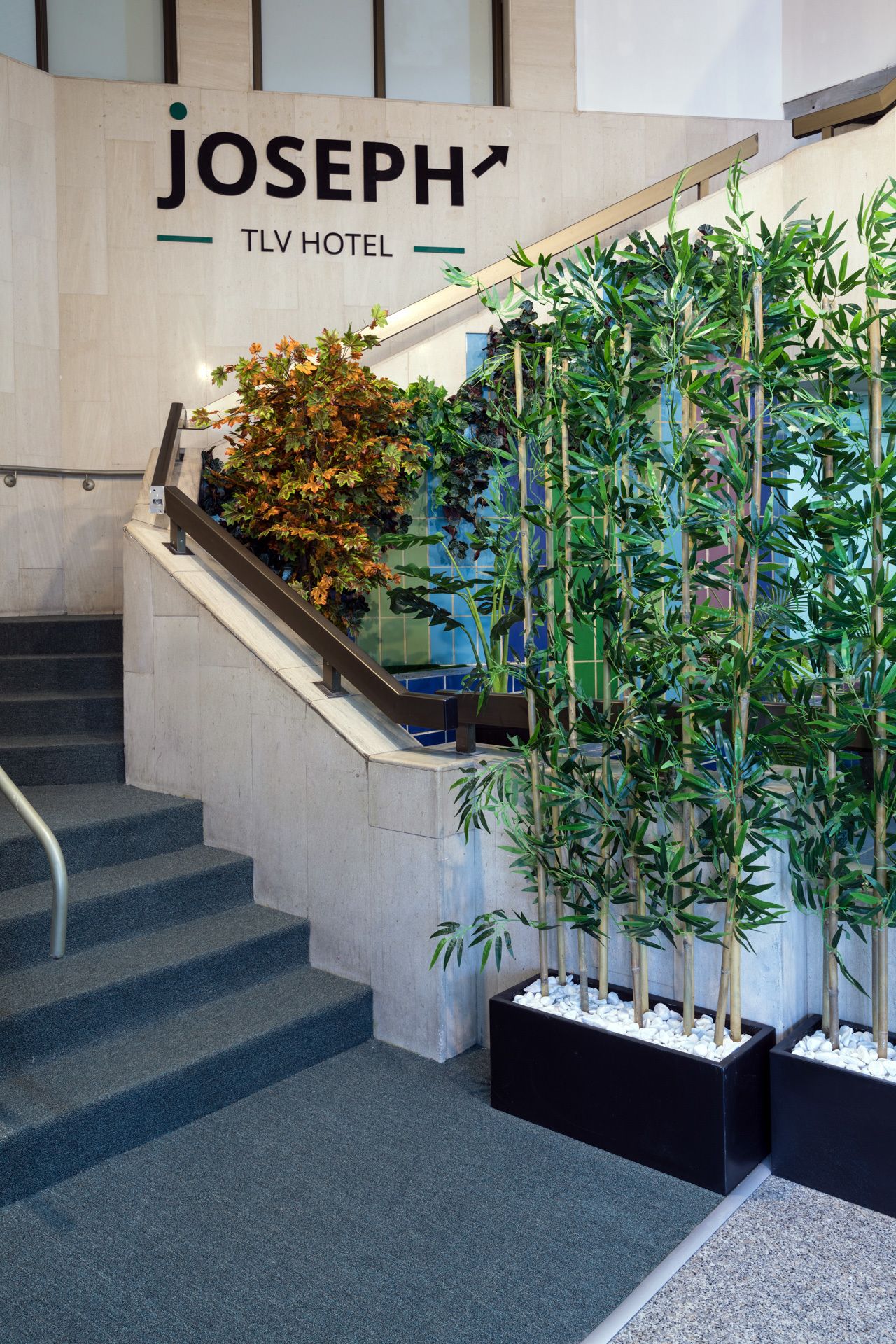 A staircase with a sign for the Joseph TLV Hotel.