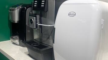 Una cafetera con pantalla digital y un logotipo de la marca en la parte frontal.