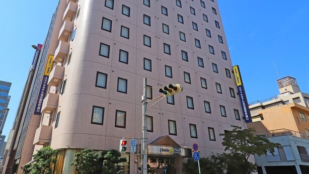 A multi-story hotel with a modern design, featuring a prominent entrance with a sign.