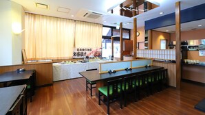 A restaurant with wooden flooring, a counter with a menu, and a seating area with tables and chairs.