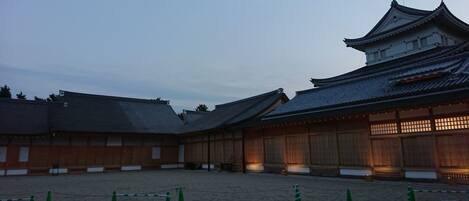 Ein traditionelles japanisches Gebäude mit Ziegeldach und Holzwänden, umgeben von einem Kieshof.