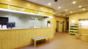 A hotel reception area with a 'Cashier' counter, a 'Smile Hotel' sign, a 'Self Amenity' section, and a 'Private' door.