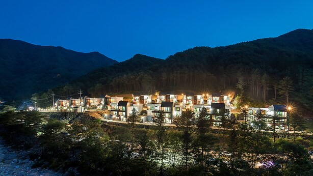 A modern hotel with multiple buildings, surrounded by mountains and trees. - Yeoninsan Hot Spring Resort (Gapyeong)