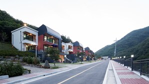 A modern residential street with houses featuring balconies and large windows. - Yeoninsan Hot Spring Resort (Gapyeong)