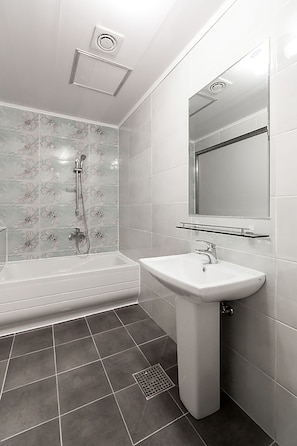 Une salle de bain moderne avec une baignoire, un lavabo et une douche.