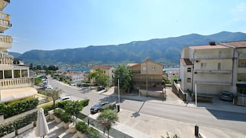 A street view with buildings, a clear sky, and mountains in the background.