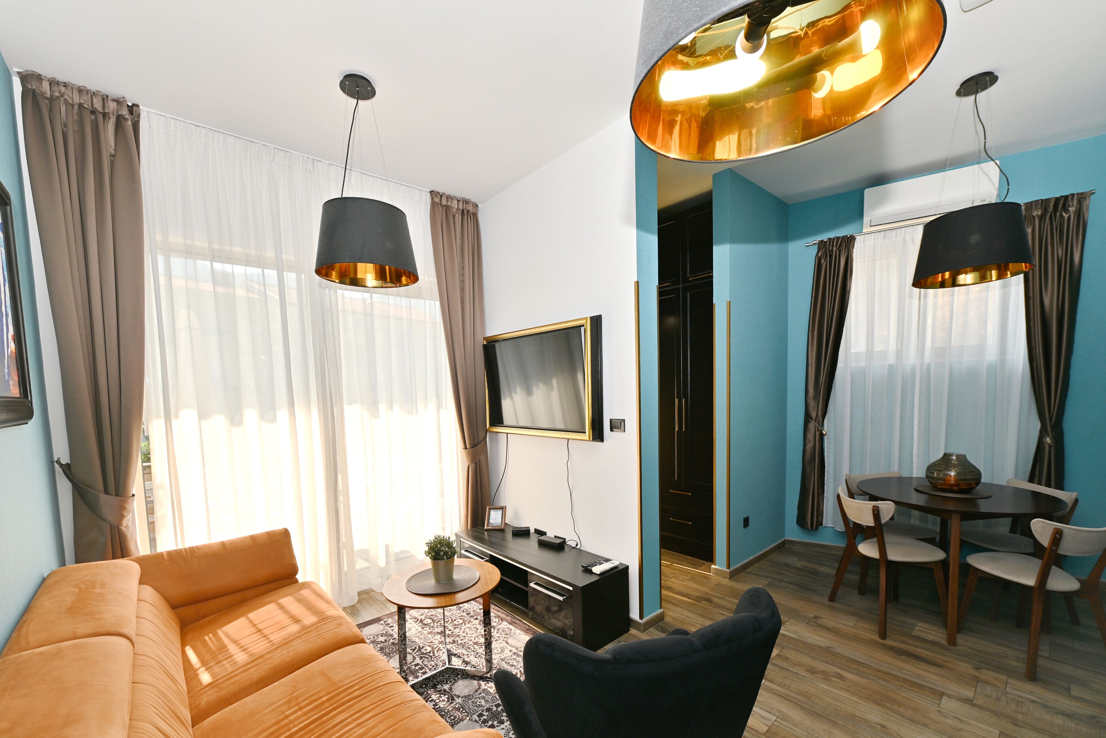 Una sala de estar moderna con sofá, televisor y comedor.