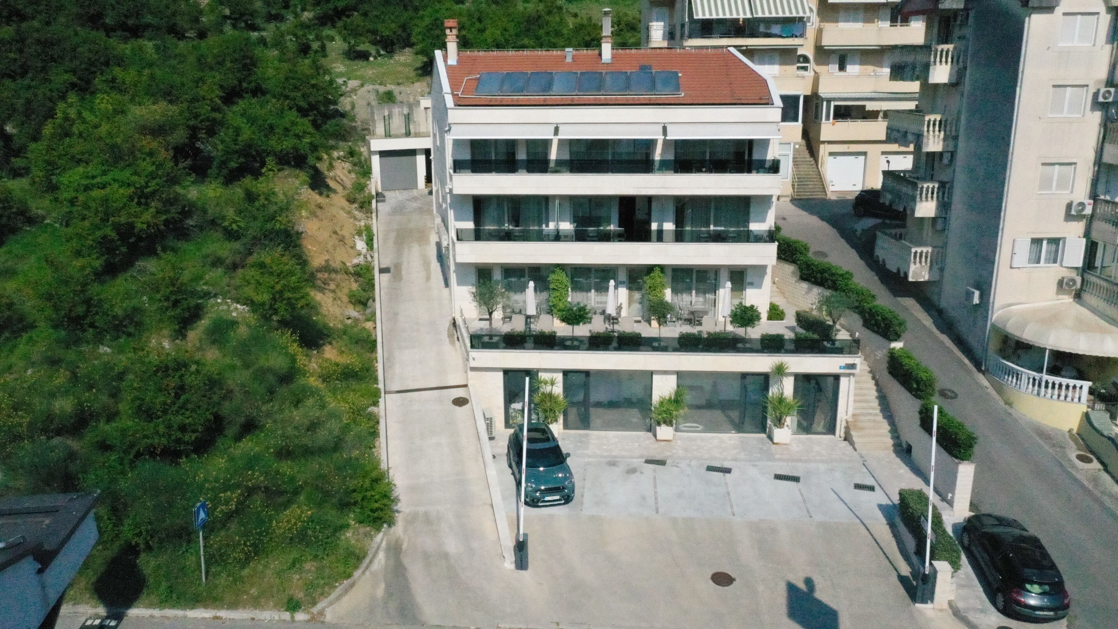 Un edificio a più piani con tetto piatto, ampie finestre e un’area di parcheggio.