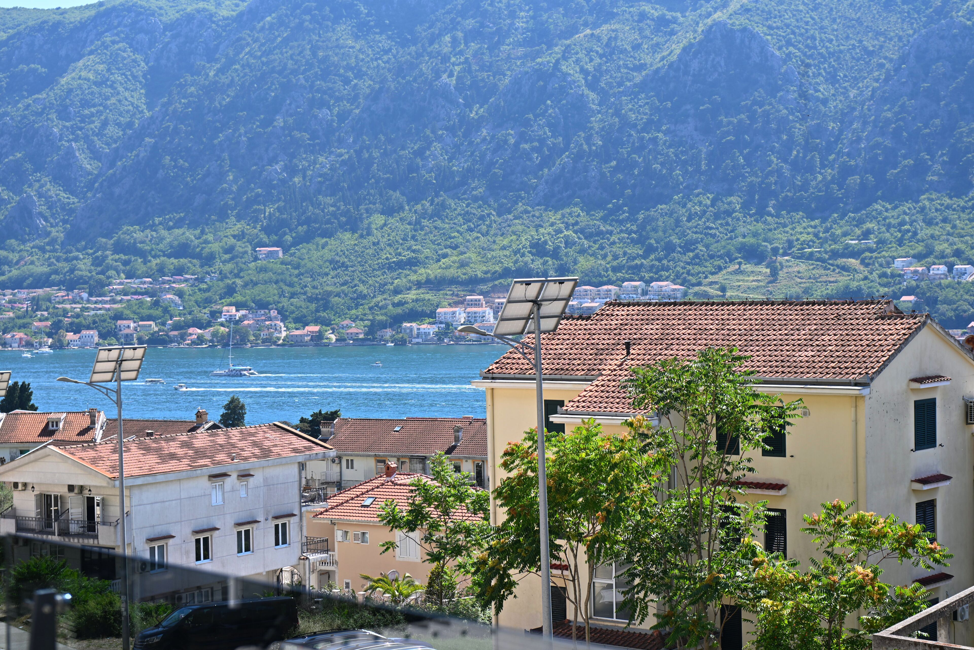 A coastal town with buildings, solar panels, and a view of the sea.