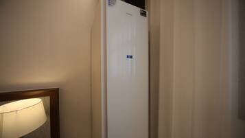 A white Samsung refrigerator in a hotel room.