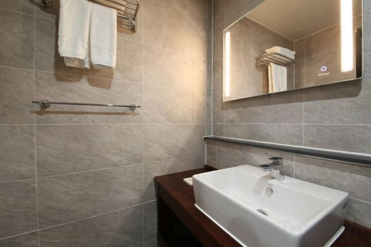 A bathroom with a white sink, a towel rack, and a mirror.
