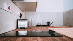 Una cocina moderna con un tostador integrado, un lavamanos y una encimera negra.