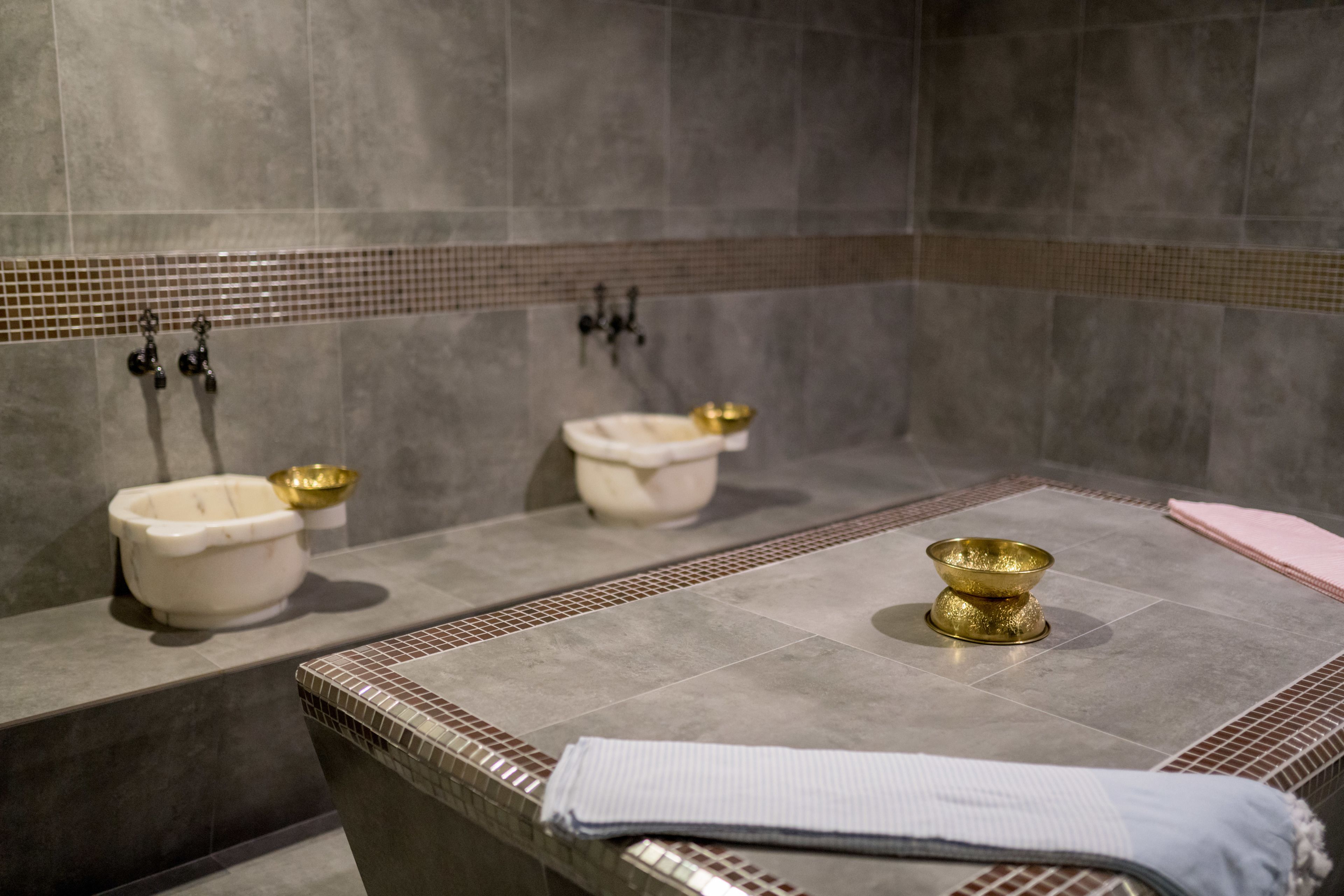 Un baño con dos lavamanos, una bañera y un perchero para toallas.