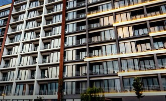 A multi-story hotel with balconies, air conditioning units, and a modern architectural design.