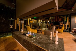 A modern lobby with a marble reception desk, comfortable seating, and a fireplace. - The Kayseri Loft Hotel (Kayseri)