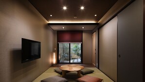Ein traditioneller japanischer Raum mit Tatami-Böden, einem niedrigen Holztisch und Kissen.