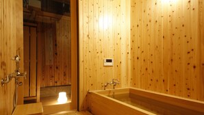 A wooden bathroom with a bathtub, a shower, and a toilet. - Kariya Ryokan Q (Ako)