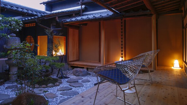 A traditional Japanese-style room with tatami flooring, a low wooden table, and a shoji screen door. - Kariya Ryokan Q (Ako)