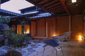 A traditional Japanese-style room with tatami flooring, a low wooden table, and a shoji screen door. - Kariya Ryokan Q (Ako)